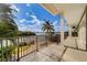 Spacious covered balcony featuring a scenic waterfront view with tropical vegetation and space for seating at 803 Harbor Dr, Belleair Beach, FL 33786
