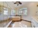 Bathroom featuring a glass enclosed shower, soaking tub, and double vanity at 803 Harbor Dr, Belleair Beach, FL 33786