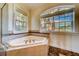 Large bathtub in bathroom with two windows overlooking the outside view at 803 Harbor Dr, Belleair Beach, FL 33786