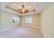 Bedroom boasts two windows, a ceiling fan, and neutral carpeting and paint at 803 Harbor Dr, Belleair Beach, FL 33786