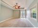 Light bedroom features a tray ceiling, neutral paint, double doors, and carpet flooring at 803 Harbor Dr, Belleair Beach, FL 33786