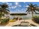 Stunning waterfront property with a luxurious pool, a boat dock, and lush tropical landscaping at 803 Harbor Dr, Belleair Beach, FL 33786
