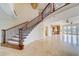 Spacious foyer with wood staircase and a view to the kitchen and backyard at 803 Harbor Dr, Belleair Beach, FL 33786