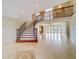 Grand foyer featuring a curved staircase, travertine floors, and decorative lighting at 803 Harbor Dr, Belleair Beach, FL 33786