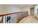 Hallway featuring hardwood floors, wood and iron banister, and a modern light fixture at 803 Harbor Dr, Belleair Beach, FL 33786