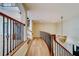 Hallway featuring hardwood floors, wood and iron banister, and a modern light fixture at 803 Harbor Dr, Belleair Beach, FL 33786