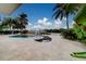 Resort-style pool and spa area with a waterfront view, complemented by lush tropical landscaping at 803 Harbor Dr, Belleair Beach, FL 33786