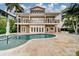 Backyard view of a luxurious home showcasing a private pool and patio at 803 Harbor Dr, Belleair Beach, FL 33786