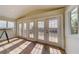 Bright sitting room with hardwood floors, multiple French doors, and a view overlooking the water at 803 Harbor Dr, Belleair Beach, FL 33786