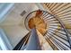 Elegant spiral staircase with wooden steps and a black metal railing ascends to the upper levels of the home at 803 Harbor Dr, Belleair Beach, FL 33786