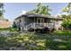 Backyard features covered patio, grassy area, and mature trees at 8517 N Branch Ave, Tampa, FL 33604
