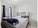 Bedroom featuring a window with natural light, neutral toned headboard and tile flooring at 8517 N Branch Ave, Tampa, FL 33604