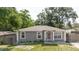 Charming single-story gray home with white trim, complemented by a well-manicured lawn and inviting entrance at 8517 N Branch Ave, Tampa, FL 33604