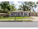 Charming gray single-story home with white trim and a lush green lawn, located on a quiet street at 8517 N Branch Ave, Tampa, FL 33604