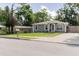 Well-maintained gray single-story home featuring white trim, a lovely front yard, and inviting curb appeal at 8517 N Branch Ave, Tampa, FL 33604