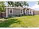 Charming single-story home featuring gray stucco and white trim, complemented by a well-maintained lawn at 8517 N Branch Ave, Tampa, FL 33604