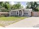 Beautiful gray single-story home with white trim, lush lawn, and a basketball hoop in the driveway at 8517 N Branch Ave, Tampa, FL 33604