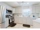 Bright kitchen features stainless steel appliances, white cabinetry, and modern tile backsplash at 8517 N Branch Ave, Tampa, FL 33604