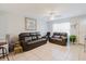 Comfortable living room with tile floors, ceiling fan, leather furniture, and a decorative painting at 8517 N Branch Ave, Tampa, FL 33604