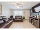 Cozy living room with a ceiling fan, tile floors, a window with blinds, and leather furniture at 8517 N Branch Ave, Tampa, FL 33604