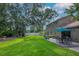 A sprawling backyard with a well-kept lawn, mature trees, and an inviting outdoor patio area at 9465 126Th Ave, Largo, FL 33773