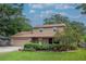 Beautifully landscaped two-story home with a brick accents, and a well-manicured lawn and garden at 9465 126Th Ave, Largo, FL 33773