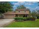 Charming two-story home featuring a brick facade, well-manicured lawn, and a welcoming two-car garage at 9465 126Th Ave, Largo, FL 33773