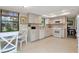 Well-lit kitchen with white cabinets, modern appliances, and a view to an adjacent dining area at 9465 126Th Ave, Largo, FL 33773