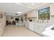 Bright, open kitchen featuring white cabinetry, sleek countertops, and a window overlooking lush greenery at 9465 126Th Ave, Largo, FL 33773