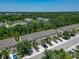 A picturesque aerial shot showcases a row of townhomes, complete with parking and surrounded by lush trees at 9720 Hound Chase Dr, Gibsonton, FL 33534