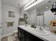 Bright bathroom with double sinks, black cabinets, and a large mirror at 9720 Hound Chase Dr, Gibsonton, FL 33534