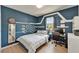 Blue-walled bedroom with a desk area and modern decor at 9720 Hound Chase Dr, Gibsonton, FL 33534