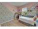 Cozy bedroom features a pink and gray wall, window, and built-in storage bed at 9720 Hound Chase Dr, Gibsonton, FL 33534