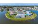 Aerial view of the waterfront community, with homes surrounded by a glistening lake and lush greenery at 1009 Andover Cir, Sun City Center, FL 33573