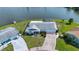 Aerial view of a waterfront property featuring a pool, lush lawns, and mature landscaping at 1009 Andover Cir, Sun City Center, FL 33573