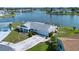 Aerial view of a charming waterfront home with a screened-in pool and mature landscaping at 1009 Andover Cir, Sun City Center, FL 33573