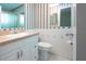 Bathroom features vanity, toilet, shower, and blue and white striped wallpaper at 1009 Andover Cir, Sun City Center, FL 33573