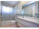 Bathroom featuring a shower-tub combo with sliding glass door, vanity with sink and a mirror at 1009 Andover Cir, Sun City Center, FL 33573