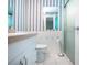 Bathroom features vanity, toilet, shower, and blue and white striped wallpaper at 1009 Andover Cir, Sun City Center, FL 33573