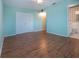 Bright bedroom with laminate floors, a ceiling fan, a closet, and an en suite bathroom at 1009 Andover Cir, Sun City Center, FL 33573