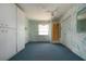 The bonus room features blue carpets and bright wall paper, with built in closets for extra storage at 1009 Andover Cir, Sun City Center, FL 33573