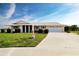 Charming single-story home with a two car garage, manicured lawn and landscaping, and a concrete driveway at 1009 Andover Cir, Sun City Center, FL 33573