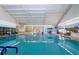 Bright indoor pool with ample seating and a serene ambiance, perfect for relaxation and aquatic activities at 1009 Andover Cir, Sun City Center, FL 33573