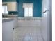 View of the kitchen featuring white cabinets, tile floors, and a bright blue wall at 1009 Andover Cir, Sun City Center, FL 33573