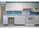 Bright kitchen with white cabinets, an oven, and a charming blue accent wall at 1009 Andover Cir, Sun City Center, FL 33573
