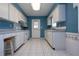 Galley kitchen with white cabinets, appliances, and a door to the outside at 1009 Andover Cir, Sun City Center, FL 33573