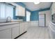 Bright kitchen with white cabinets, updated appliances, and light blue walls at 1009 Andover Cir, Sun City Center, FL 33573