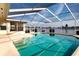 Enclosed pool with clear blue water and a view of the lake beyond at 1009 Andover Cir, Sun City Center, FL 33573