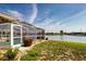 Screened-in pool offering serene waterfront views with lush lawn and water views at 1009 Andover Cir, Sun City Center, FL 33573
