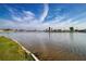 Scenic waterfront view with grass and a concrete barrier along a lake in a well-manicured neighborhood at 1009 Andover Cir, Sun City Center, FL 33573